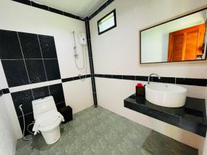 高兰Phurin Thara Resort的一间带卫生间、水槽和镜子的浴室