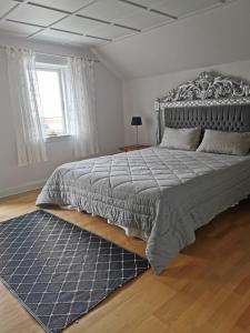 博恩瑟gl. Havn BnB的一间卧室配有一张大床和蓝色地毯。