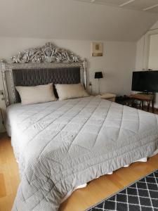 博恩瑟gl. Havn BnB的一间卧室配有一张带银色床头板的大床
