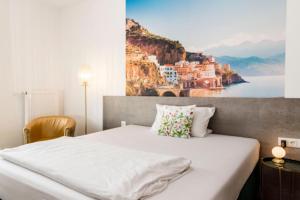 帕尔斯贝格Hotel Garni Villa Toskana的卧室配有一张大床,墙上挂有绘画作品