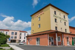 帕尔斯贝格Hotel Garni Villa Toskana的街道上一座黄色和橙色的建筑,有建筑