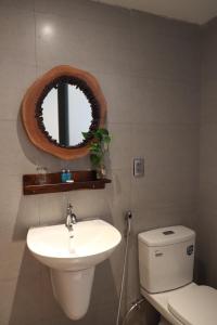 Buôn Kô SirAmacon Hotel & Coffee的一间带卫生间、水槽和镜子的浴室