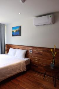Buôn Kô SirAmacon Hotel & Coffee的酒店客房配有一张床铺和一张桌子。