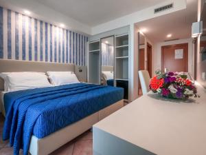 马拉泰亚马蒂诺酒店的一间卧室配有一张床和一张鲜花桌