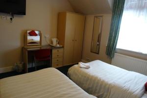 斯劳AJ Lodge的酒店客房设有两张床、一张书桌和一个窗户。