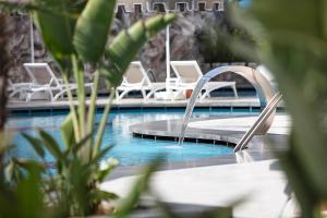 科纳克勒Blue Marlin Deluxe Spa & Resort - Ultra All Inclusive的一个带白色椅子的游泳池和一个游泳池