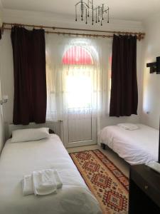 格雷梅Cappadocia Kepez hotel的一间卧室设有两张床、一个窗户和一个吊灯。