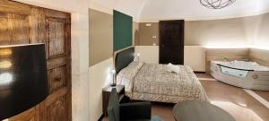 拉奎拉San Marciano Luxury Rooms的一间卧室配有一张床、一个浴缸和一个水槽