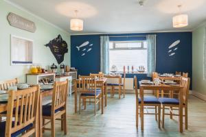 尚克林罗伊逊宾馆的餐厅设有木桌和椅子,拥有蓝色的墙壁
