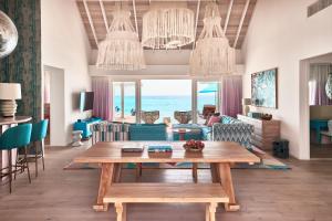 芭环礁Finolhu Baa Atoll Maldives的客厅配有桌子,享有海景