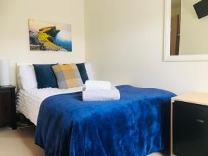 波特里Feochan Rooms Portree的一间卧室配有一张带蓝色毯子的床