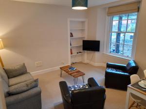 本泰兰Burntisland Garden Apartment, Fife - 40 mins to Edinburgh的客厅配有两把椅子和电视