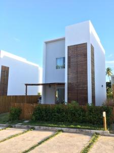 因巴塞Casa duplex de temporada em Imbassai的一座带木栅栏的大型白色房屋