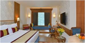 艾哈迈达巴德Fortune Landmark, Ahmedabad - Member ITC's Hotel Group的配有一张床和一张书桌的酒店客房