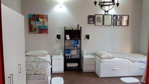 BorgofortePalazzo Adalgisa的配有白色橱柜的客房内的两张床
