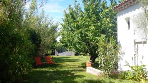 埃瑞兹le gîte Lou Jas的一个带长凳和树木的院子和房子