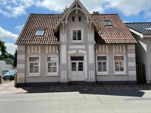 新明斯特CityGlückNms - Direkt am Bahnhof und Einkaufszentrum的白色房子,有棕色的屋顶