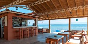 卡沃斯海滨公寓 的餐厅设有酒吧,背景为大海