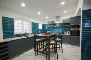 法鲁Qta do Eucalipto Villa的厨房铺有蓝色瓷砖,配有桌椅