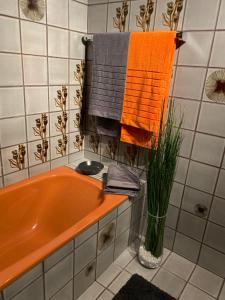 沃尔特湖畔佩莎赫Apartment Ananas I Zentral & SeeNah的浴室设有橙色浴缸,配有毛巾
