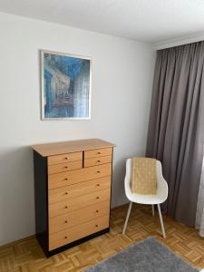 沃尔特湖畔佩莎赫Apartment Ananas I Zentral & SeeNah的一间卧室配有梳妆台和椅子