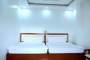朱笃HOTEL ĐĂNG KHOA 1 NÚI SAM的两张睡床彼此相邻,位于一个房间里