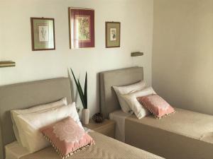 布卡里Aliki Studios的卧室内的两张床,配有粉色和白色枕头