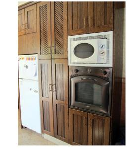 阿尔加尔Alojamiento rural " Las Carmenes "的厨房配有木制橱柜、微波炉和冰箱。