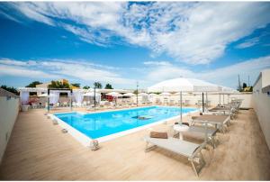 夏卡Bono Vacanze Villa San Marco Luxury Holidays Homes & Hotel的一个带躺椅和遮阳伞的大型游泳池