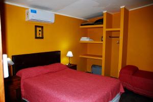 圣拉斐尔La Aldea的一间卧室设有红色的床和黄色的墙壁