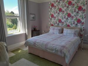 赖德Grantham House的一间卧室配有一张带花卉壁纸的床
