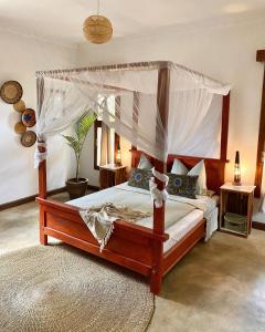 阿鲁沙Utamaduni House B&B的一间卧室配有一张天蓬床和地毯。