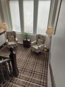 斯特拉西尔The Ben Sheann的客厅配有两把椅子和两扇窗户