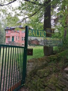 波兰尼卡-兹德鲁伊Baltic Home的树后有粉红色建筑的栅栏