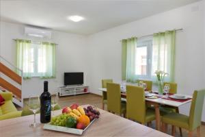 普拉Apartment Olivix的用餐室配有带1瓶葡萄酒和水果的桌子