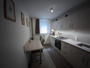SzarvaskőSzarvaskő Vendégház的厨房配有白色橱柜和木制台面