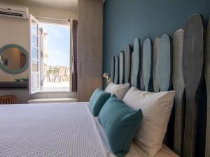 费斯卡尔德宏FiscardoStudios的一间卧室配有一张带大型木制床头板的床