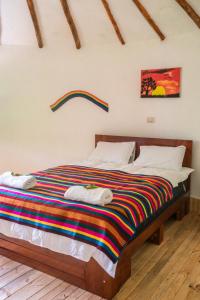 YungayTullpa Rumy的一间卧室配有一张带彩色毯子的床