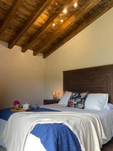 FresnoVivienda Vacacional Del Busto的一间卧室设有一张大床和木制天花板。