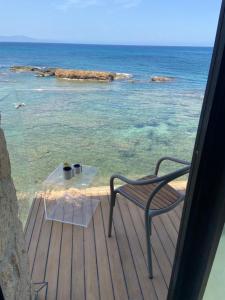 干尼亚The Tanneries Hotel & Spa的玻璃桌和椅子,在海景甲板上