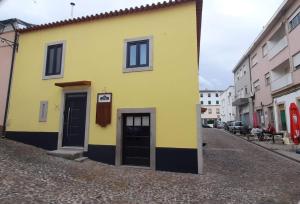 米兰德拉Taska Vila Velha的街道上带黑色门的黄色建筑