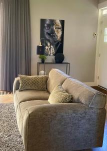 沃德里赫姆Hoeve Altena Apartment的客厅里一张棕色的沙发,上面有绘画作品