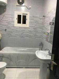 塔伊夫كريستال الذهبية的带浴缸和盥洗盆的浴室