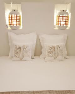 法维尼亚纳Casa Mirella的床上配有2个白色枕头和2盏灯