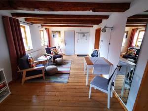 伊尔森堡"Heckenrose"的客厅铺有木地板,配有桌椅。