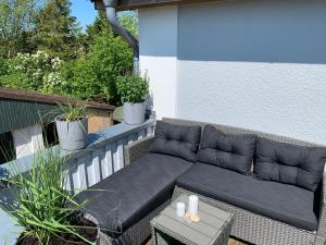 费马恩Henkieker - ländliche Ferienwohnung mit Stil的一张黑色沙发,坐在带桌子的阳台