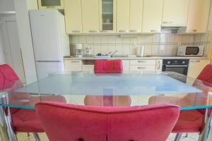 特罗吉尔约瑟夫和玛丽公寓的厨房配有玻璃桌和粉红色的椅子