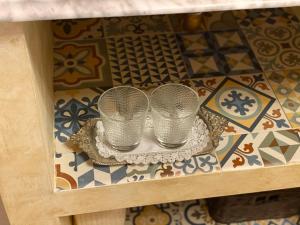 桑卢卡尔-德巴拉梅达Lujosa suite privada en casa del S XIX的瓷砖地板上盘子上的两个银杯