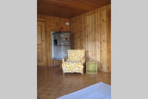 卡森里德Alpia 26 - Zwei Zimmerwohnung in traditionellem Walliser Haus的客厅配有椅子和烤箱