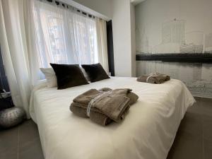 马拉加PLAYA, SOL Y CENTRO HISTORICO的卧室配有白色床和毛巾